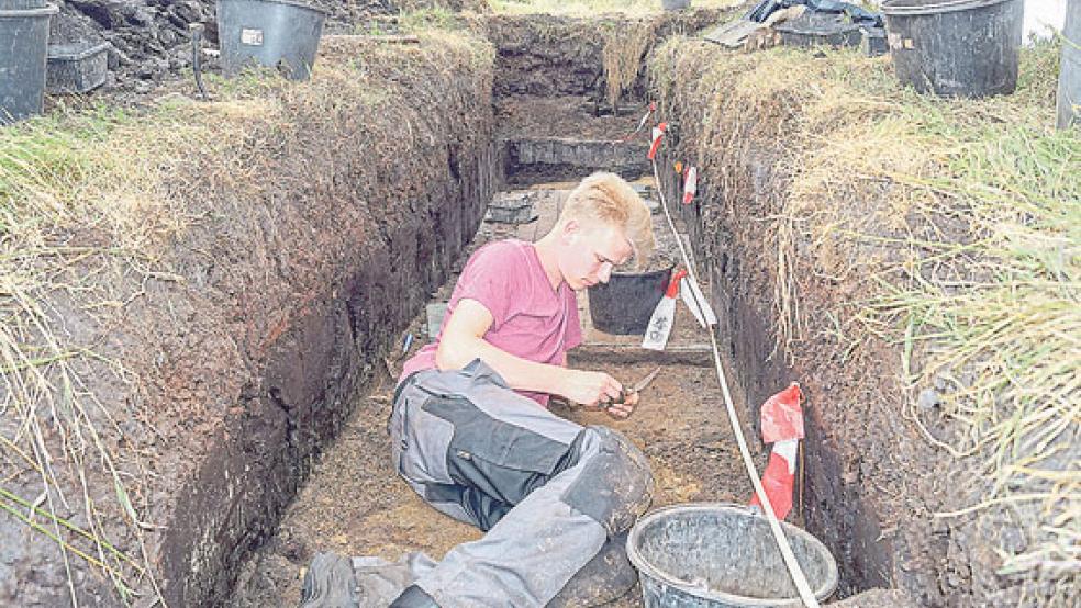 Feintuning und Fingerspitzengefühl: Grabungspraktikant Lars Schüler von der Universität Rostock untersucht in dem archäologischen Graben mit Kelle und Baukübel einen Steinfund, den er in einer der tieferen Schichten entdeckt hat. © Foto: Krull