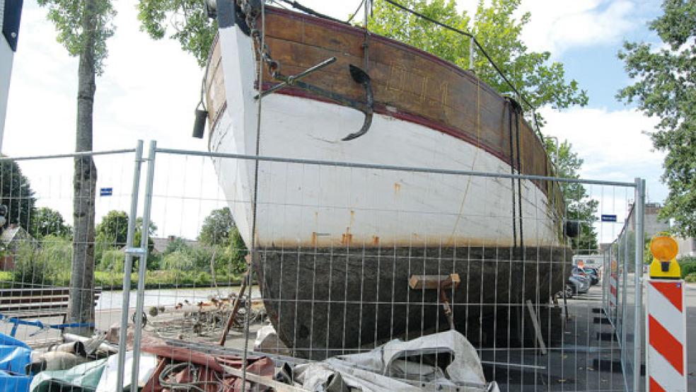 Der Kutter »Miltiades« steht mittlerweile direkt am Hafenufer auf einem Wohnmobilstellplatz und ist aus Sicherheitsgründen von einem Zaum umgeben.  © Foto: Hoegen
