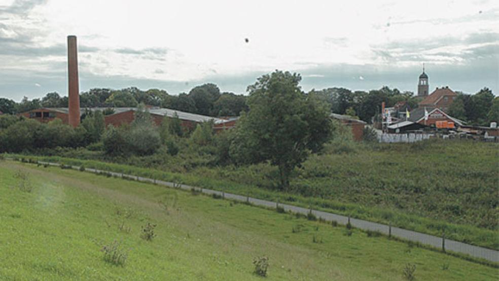 Der Blick vom Emsdeich zeigt das Gelände der ehemaligen Ziegelei Reins in Jemgum und rechts den Baustoffhandel Mennenga, der in die Planungen einbezogen wird. Im Falle einer Fördermittel-Zusage wäre auch eine Umsiedlung des Baustoffhandels an den Ortsrand denkbar. © Foto: Szyska