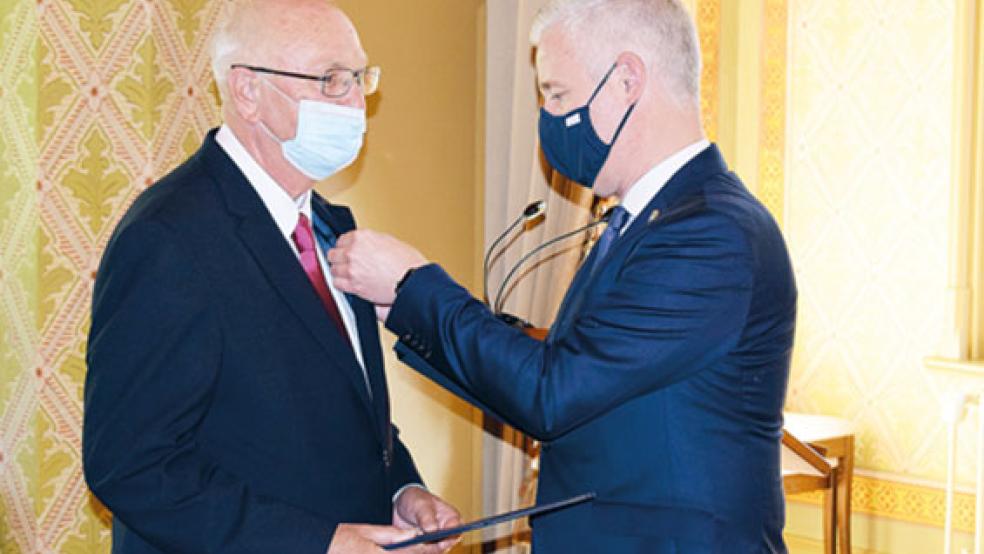 Ans Revers heftete Landrat Matthias Groote dem Regionalforscher Hermann Adams die »Verdienstmedaille des Verdienstordens der Bundesrepublik Deutschland«. © Foto: Landkreis Leer
