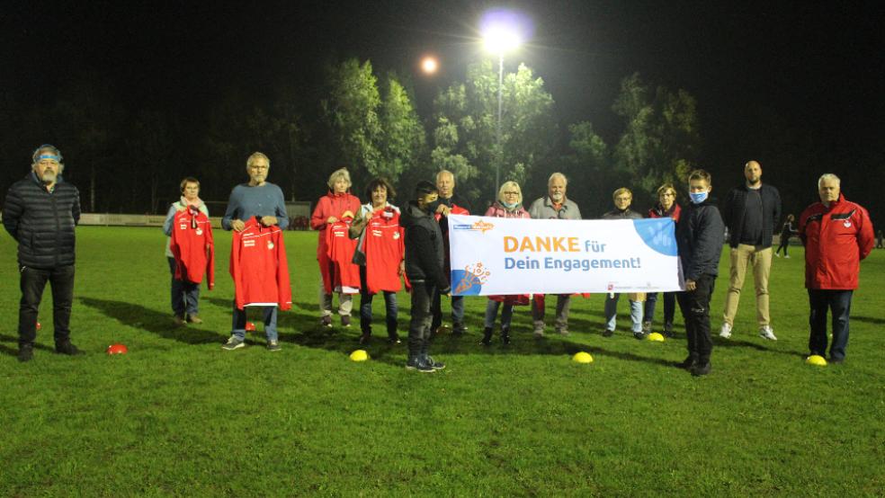 Der SV Ems Jemgum ehrte jetzt ehrenamtliche Helfer für ihr Engagement. Das Foto zeigt von links: Egge Mansholt (KSB Leer), Anne Lindmann, Martin Hinderks, Elke Hüncke, Brunhilde Behrends, Helmut Pilney, Edeltraut Nagel, Hans-Joachim Behrends, Nette Nitters, Karin Hinderks, Jens Flink (Vorstand SV Ems) und Helmut Bugiel (Geschäftsführer SV Ems). Das Banner halten zwei Jugendspieler des Vereins. © Foto: Berents