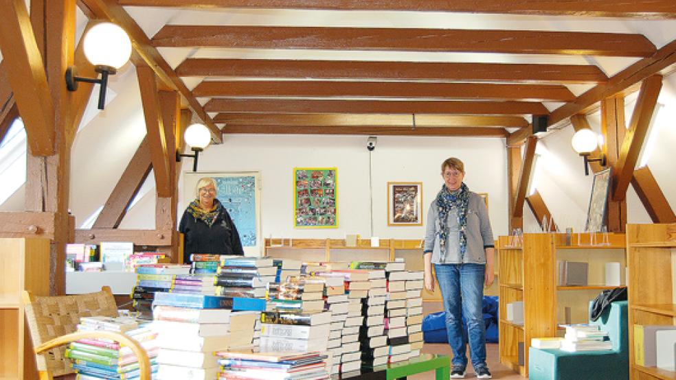Bücherstapel und leere Regale: Die Jugendbücherei der Stadtbücherei Weener wird derzeit komplett umgestaltet. Links im Bild Bücherei-Leiterin Susanne Fokkens, rechts ihre Kollegin Dagmar Trautmann. © Foto: Hoegen