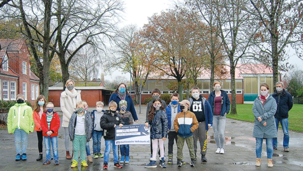 Auf dem Schulhof der Pestalozzischule übergab Ilka Hilbrands (Dritte von rechts) gestern den symbolischen Spendenscheck an eine Gruppe von Schülerinnen und Schülern, die den Gast von der Oberschule zusammen mit ihren Lehrerinnen und Lehrern begrüßten. © Foto: Hoegen