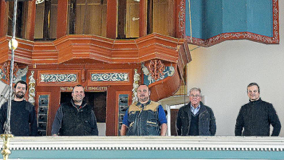 Bauen die Orgel jetzt in der Uttumer Kirche wieder auf: die Orgelbauer Vincent Paffen, Dennis Backer und Arno Beitelmann (v.l.) sowie Thomas Boelmann (r.) auf der Galerie. Zwischen ihnen steht Uttums Kirchenmeister Temmo Hollander (2.v.r.). © Foto: Pries