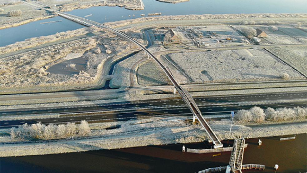 Auf dieser Luftaufnahme mit einer frostigen Landschaft sind die vier Brückenelemente der 800 Meter langen »Pieter Smitbrug« gut zu sehen. Unten in der Nähe des Winschoter Stadtparks wird mit einer Klappbrücke der »Winschoter Diep« überquert, danach die Autobahn A7, dann ein Stück Naturschutzgebiet und oben links, immer weiter abflachend, ein Teil des Oldambtmeeres. © Foto: Provinz Groningen 