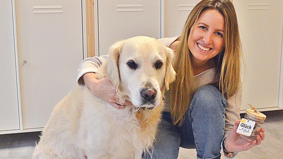 Vera Buschmann und Hund »Percy« mit dem neuesten Produkt: »Glück in’t Glaske mit Plattkeks«.  © Foto: Ammermann