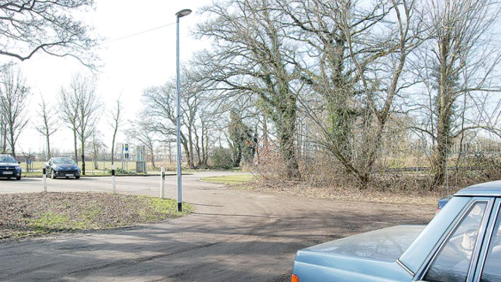 Nur mit Schlacke befestigt ist bislang der Parkplatz am Kindergarten in Stapelmoor. Die enge Einfahrt kann hier durchaus für gefährliche Situationen sorgen. Der SPD-Ortsverein fordert schon lange eine Neugestaltung des Parkplatzes. Schlecht zu erkennen im hellen Sonnenlicht ist das Stromkabel, das vom Lampenkopf in Richtung Kindergarten führt.  © Foto: Hoegen