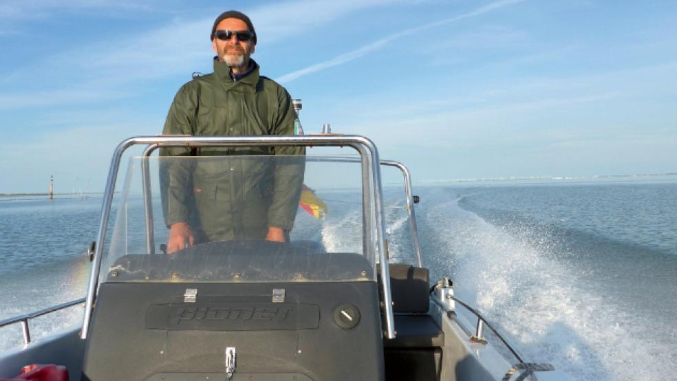 Enno Janßen steht am Steuer seines Motorboots bei einer Fahrt durch das Wattenmeer. © Foto: Droemer Knaur Verlag | Leo G. Linder