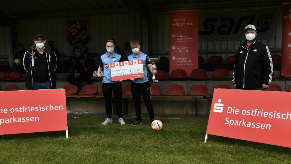 Helge und Dominik Thiele (Mitte) von Concordia Suurhusen wurden von Philippe Olsson (links) und Michel Rolandi für ihren Sieg in der Ostfrieslandliga geehrt.  © Foto: NFV-Kreis Ostfriesland