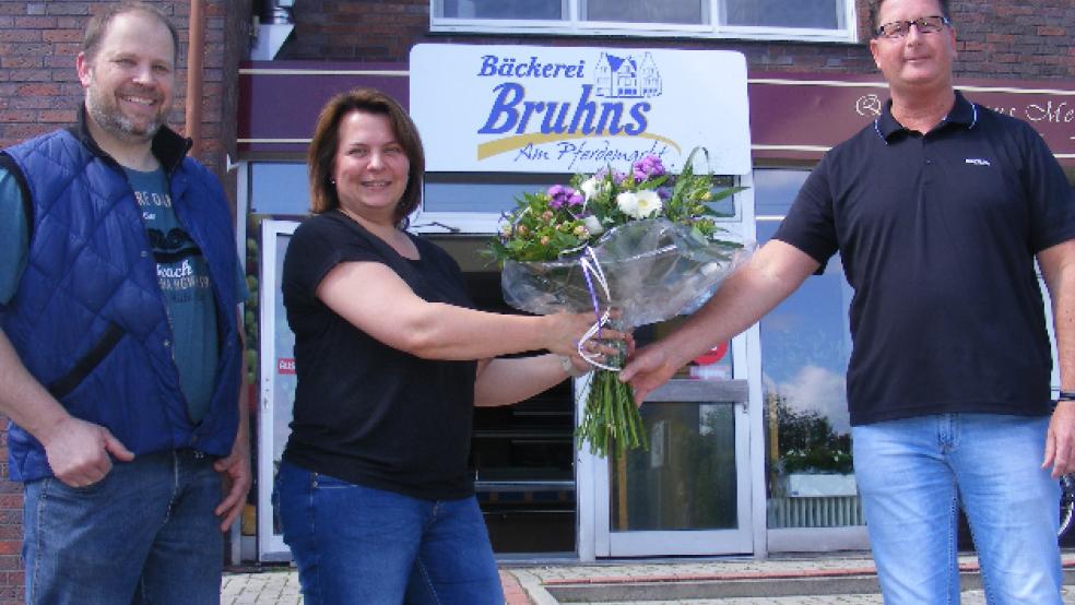 Bingums Ortsvorsteher Sönke Eden (SPD, rechts) begrüßte Enno und Sandra Bruhns mit einem Blumenstrauß. © Foto: Szyska