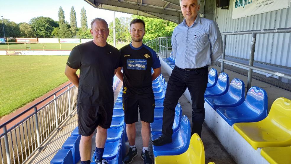 Christian Rosendahl (von links) und Thorben Dirks wurden als neues Trainer-Duo von Germania Leer von Ferhat Özdemir vorgestellt. Im Hintergrund trainiert die Mannschaft. © Foto: Born