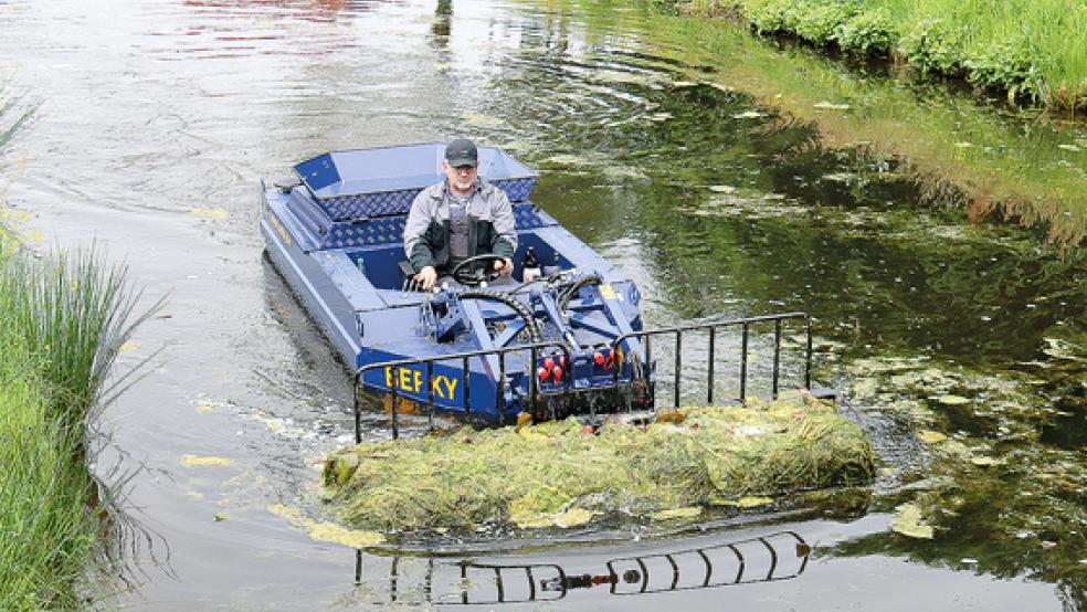 Erstmals hat die Gemeinde Ihlow mit einem Befall von Fadenalgen zu kämpfen - doch die Verantwortlichen wissen sich zu helfen. Sie haben ein sogenanntes Mähboot gechartert, um der Plage Herr zu werden. Unter der Wasseroberfläche mäht das Mähwerk, das am vorderen Ende des Bootes befestigt ist, den Boden der Kanäle ab..  © Foto: Ruhr