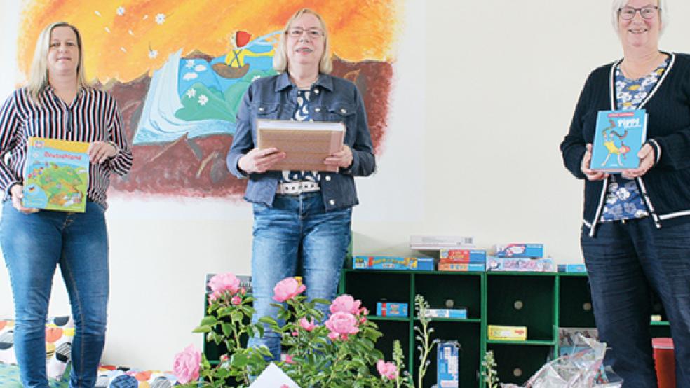 Anita Timmer (Mitte) verabschiedet sich in den Ruhestand. Susanne Fockens (rechts) überreichte ihrer langjährigen Kollegin unter anderem ein Fotoalbum mit Bildern der vergangenen 22 Jahre. Silke Freese (links) wird nach den Sommerferien Timmers Nachfolge antreten.  © Foto: Berents