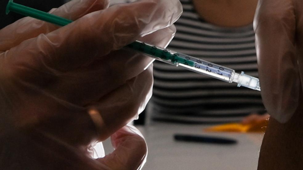 Ein Patient erhält eine Coronaimpfung. Im Impfzentrum in Hesel will der Landkreis Leer jetzt auch Kreuzimpfungen anbieten.<br />  © Foto: dpa