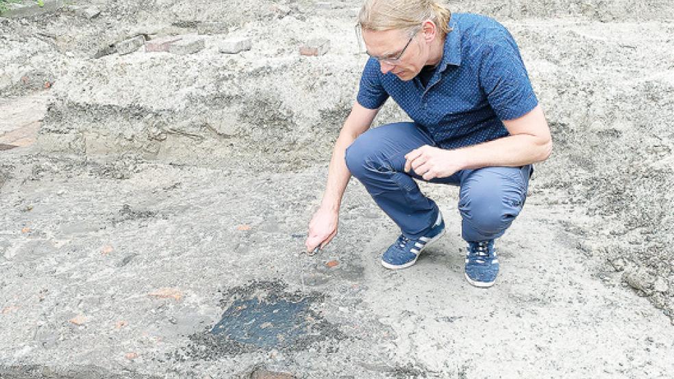 Archäologe Dr. Jan Kegler vor den Steinfundamenten der Synagoge. Die schwarzen Verfärbungen sind Zeugnisse des verheerenden Brandes von 1938, bei dem das Gotteshaus in Schutt und Asche gelegt wurde.  © Foto: Hanken