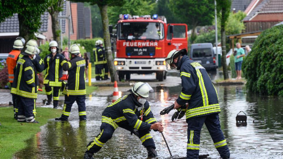 Die Feuerwehrleute öffneten Gully-Deckel und Abwasserschächte, damit die Wassermassen schneller ablaufen konnten. Unser Bild entstand in der Möwenstraße in Möhlenwarf. © Foto: Bruins