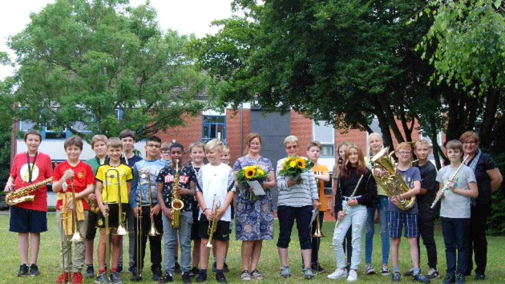 Die Mädchen und Jungen der aktuellen Bläserklasse der Oberschule Weener zusammen mit Andrea Sinning (Mitte, rechts) und Jannette de Boer. Beide wurden gestern als Instrumentallehrerinnen verabschiedet. Ganz rechts Christiane Meyer. © Foto: Hoegen