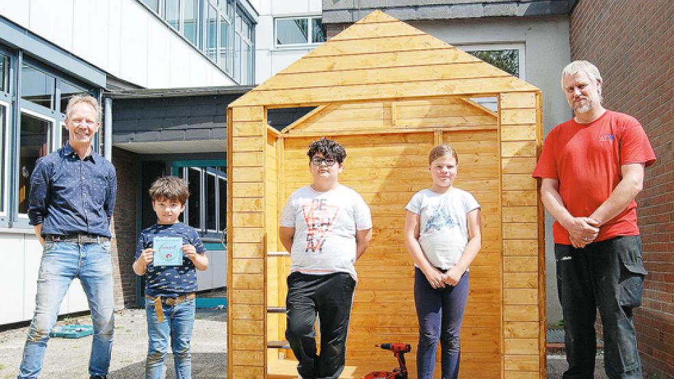 Das Gartenhäuschen ist bald fertig. Von links Folkert Kruse, Joel Kruse, Parsa Kosar, Leonie Smid und Holger Smid. Zusammen mit Imken Sanders - nicht im Bild - waren sie am Sonnabend bei einer Ferienaktion auf dem Schulgelände aktiv.  © Fotos: Hoegen