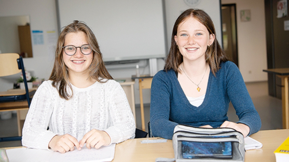Marietta (links) und Pauline sitzen in ihrem Klassenzimmer in der Inselschule von Baltrum.  © Foto: Sina Schuldt (dpa)