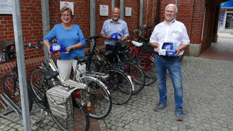 Georg Reichelt (rechts) von der Verkehrswacht Leer und sein Auricher Kollege Hans-Friedel Walther präsentieren mit Brandkassen-Sprecherin Signe Foetzki die neuen Helme.  © Jürgens