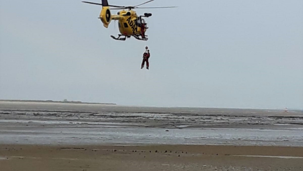 Mit einer Seilwinde birgt die Besatzung des Rettungshubschraubers einen der beiden Hilfebedürftigen aus dem Watt vor der Insel Baltrum. © Feuerwehr