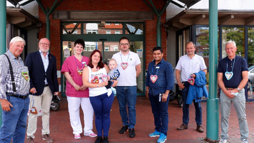 Der Vorsitzende des Schaustellervereins Ostfriesland, Karl-Heinz Langescheidt, Papenburgs stellvertretender Bürgermeister Heiner Butke, Schwester Tanja, Mutter Daniela Neumann mit dem kleinen Adrian, der Chefarzt der Kinder- und Jugendmedizin Torsten Kautzky, der diensthabende Kinderarzt Subba Rao Varanasi, der Erste Stadtrat Hermann Wessels sowie Ralf Langescheidt bei der Übergabe der Lebkuchenherzen.  © Foto: Stadt Papenburg