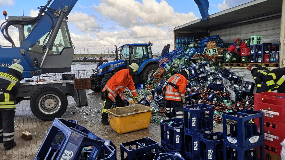 Einiges an Getränkeflaschen ging im Hafen von Juist zu Bruch, als ein mit Kisten beladener Anhänger umstürzte. Die Feuerwehr half bei den Aufräumarbeiten. © Feuerwehr