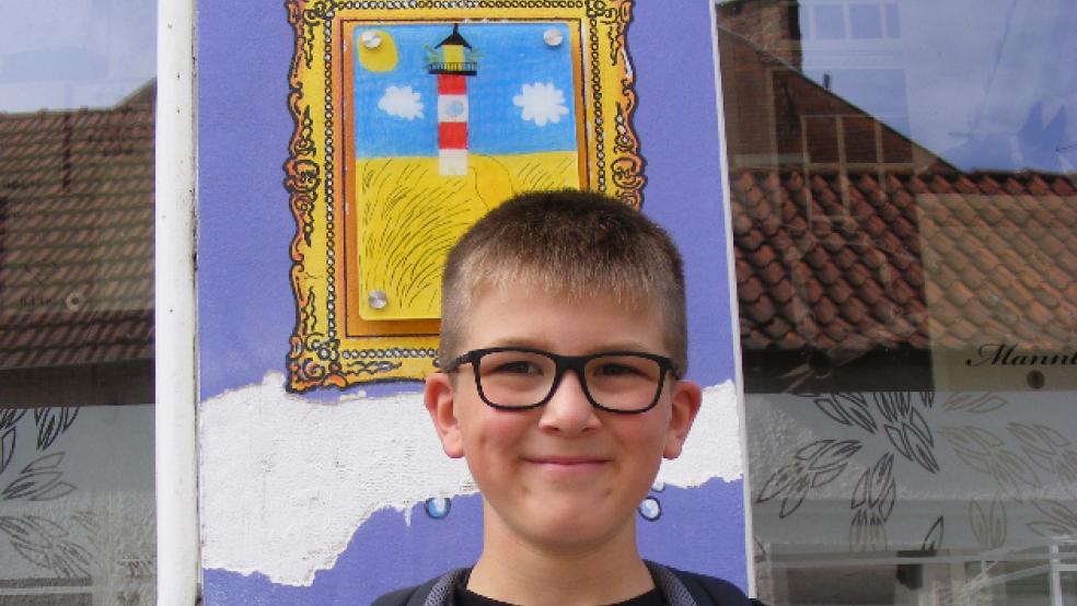 Stolzer Gewinner: Lewis Meyer von der Grundschule Bingum vor seinem Leuchtturm-Bild am »Coloniale-Haus«. © Foto: Szyska