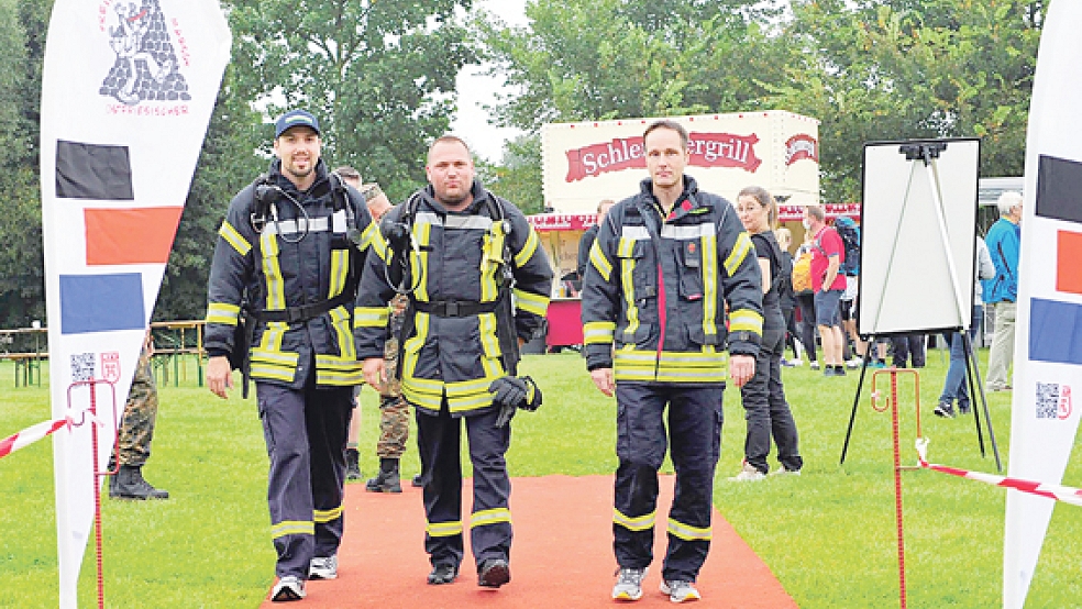 Mario Eilers, Alexander Suntken und Per Wolfenberg starteten beim dritten Ostfriesischen Freiheitsmarsch in Aurich mit voller Schutzbekleidung.  © Foto: Feuerwehr 