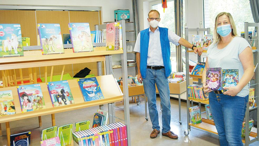 Neuer Standort für die Bücherei in der Grundschule Möhlenwarf ist der ehemalige Musikraum der Schule.Im Bild Schulleiter Thomas Stern und Silke Freese, Leiterin der Außenstelle der Stadtbücherei, mit zwei Usch Luhn-Büchern.  © Foto: Hoegen