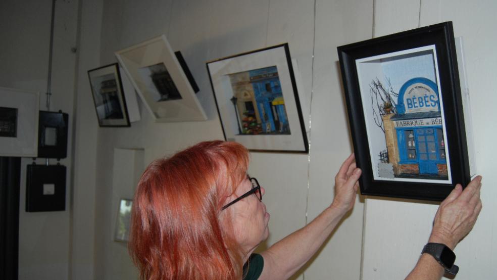 Catharina Bockhacker mit einem der Vitrinenbilder von Peter Geelen.  © Foto: Hoegen