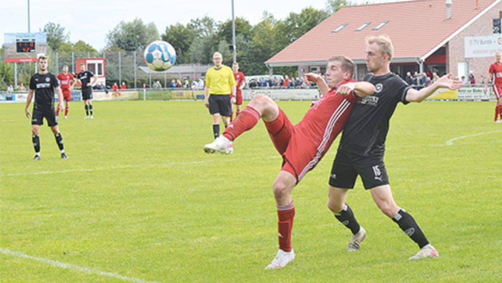 Lukas Kappernagel erzielte vier Minuten vor dieser Szene sein erstes Saisontor. Gegen Ralf Aden (rechts) den SV Großefehn hatten er und seine Bunder Mitspieler dennoch weitestgehend einen schweren Stand.  © Foto: Born