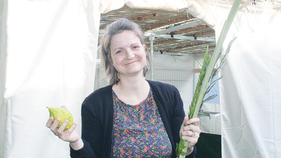 Susanne Bracht mit der Etrog-Frucht und dem Zweig einer Dattelpalme vor der »Sukka« (Laubhütte). Die EJS beteiligt sich an der Aktion »Sukkot XXL«.  © Foto: Berents