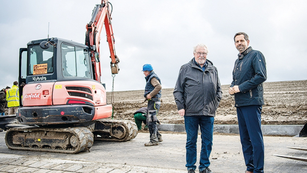 Oberdeichrichter Alwin Brinkmann (links) steht mit Olaf Lies (SPD) auf der Deichbaustelle in Upleward.  © Foto: Schuldt (dpa)