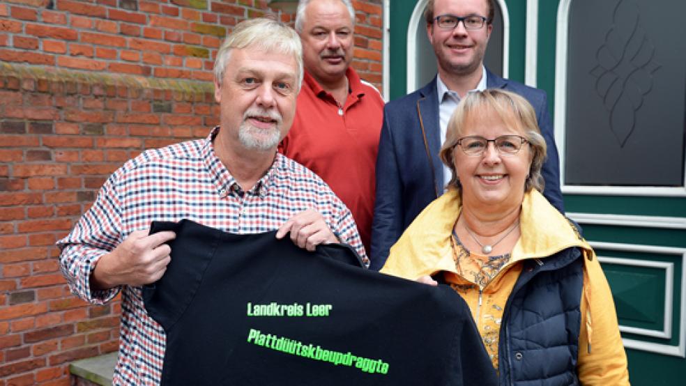 Gertrud Reitmeyer (rechts) übergibt die Aufgabe der Plattdeutschbeauftragten an Jan-Martin Donker. Hinten: Bei einer kleinen Feierstunde waren auch Artur Reents (links) als Plattdeutschbeauftragter und Markus Harms, stellvertretender Amtsleiter des Amtes für Schule, Bildung und Kultur, dabei.  © Foto: Landkreis Leer