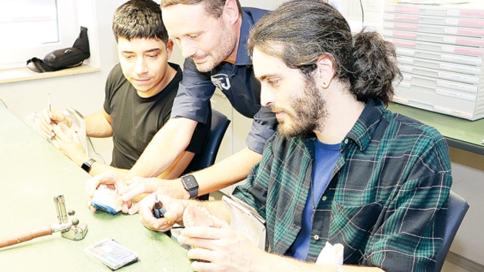 Geschäftsführer Thomas Maur (Mitte) zeigt Josep Alfonso Peinado (links) und Jan Ricard Nugué Marques bei der Modellierung einer Zahnprothese noch einen Handkniff.  © Foto: HWK/W.Feldmann