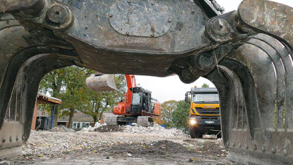 Blick durch den Greifer eines Baggers auf das Schulgelände in Collinghorst. Dort werden gerade die Reste eines ausgebrannten Schultraktes abtransportiert.  © Foto: Wieking