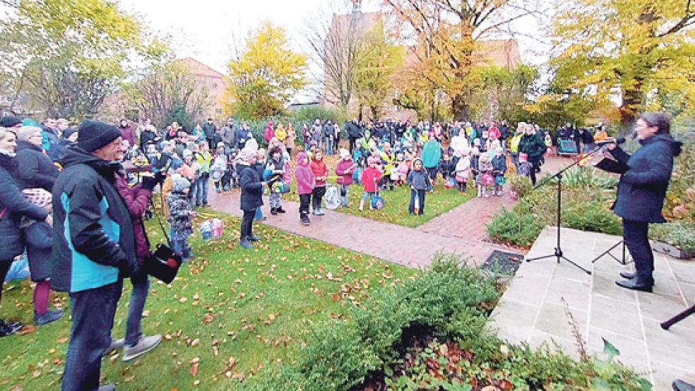 Das Laternenfest in Stapelmoor begann mit einer gemeinsamen Andacht vor dem Pfarrhaus mit Pastorin Barbara Wündisch-Konz (rechts im Bild). Anschließend machten sich die Kinder und ihre erwachsenen Begleiter auf den Weg in den Park.  © Foto: privat
