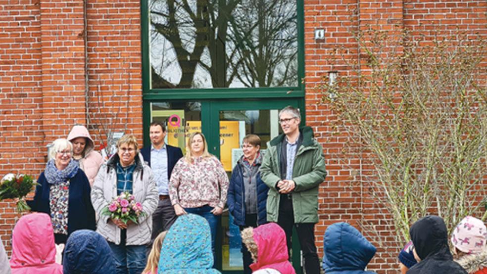 Sichtlich bewegt nahmen Susanne Fockens und Birgitt de Riese - beide mit Blumensträußen vorne links - vor der Stadtbücherei die vielen guten Wünsche bei ihrer Verabschiedung entgegen. Rechts im Bild Bürgermeister Heiko Abbas.  © Foto: Stadt Weener
