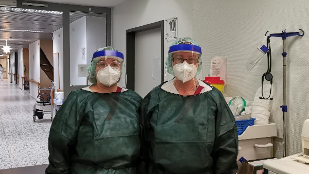 In voller Montur auf dem Flur der Isolierstation im Borromäus-Hospital in Leer: Für die Pflegekräfte Mareike Ölscher und Wanda Lakeberg (von links) ist die alltägliche Arbeit mit den Covid-Patienten sowohl körperlich als auch psychisch anstrengend. © Foto: Henschel (Borromäus-Hospital)