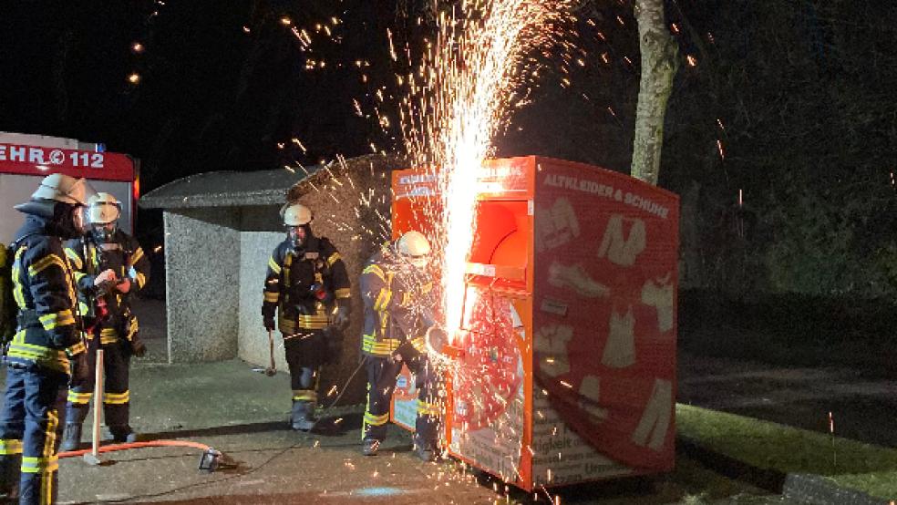 Mit einer Flex öffneten die Feuerwehrleute den Container, um die brennenden Altkleider löschen zu können. © Foto: Boelmann