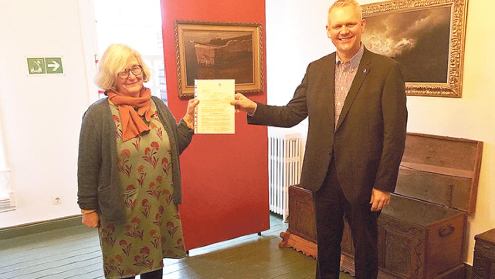 Hilke Boomgaarden, 1. Vorsitzende des Heimatvereins Leer, bekommt den Förderbescheid von Wissenschaftsminister Björn Thümler.  © Foto: Oliver Freise