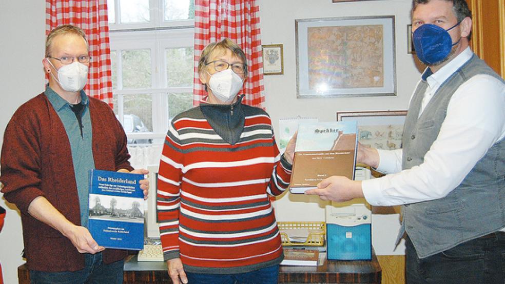 Ein Exemplar der von ihm verfassten Familienchronik übergab Dietmar Spekker am Freitag an Friedel Popkes, Leiterin der Bibliothek des Heimatvereins, und an Museumsmitarbeiter Herbert Borchers (links). Spekker bekam ein Exemplar von »Das Rheiderland«.  © Foto: Hoegen
