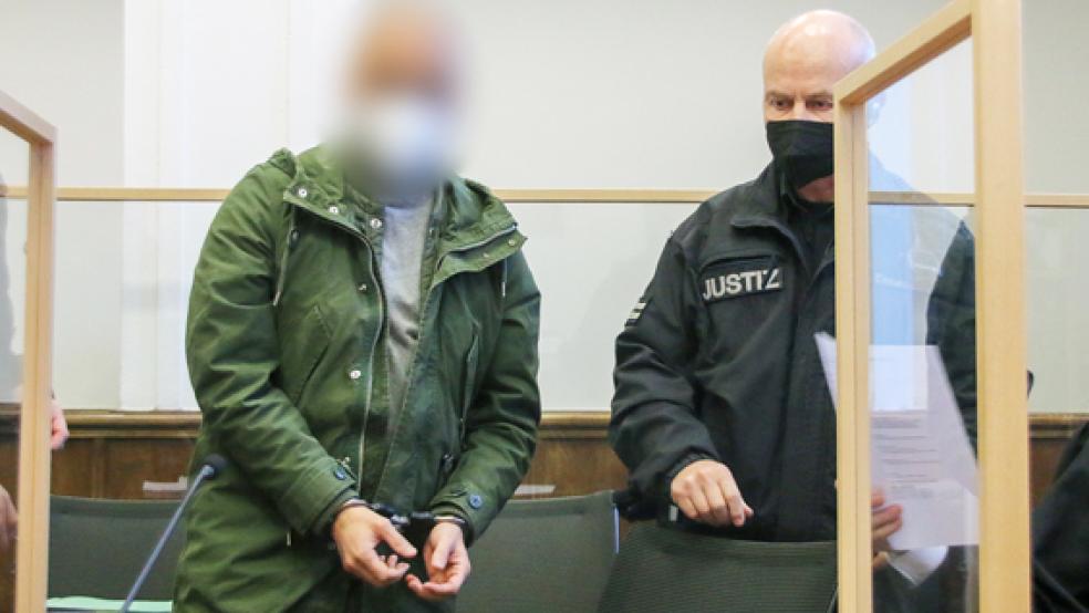 Ein Angeklagte wird von einem Justizbediensteten zu Beginn eines Prozesses vor dem Landgericht Aurich an seinen Platz geführt. Der Angeklagte soll zusammen mit drei weiteren Männern Teil einer Schleuserbande gewesen sein.  © Foto: Lennart Stock/dpa