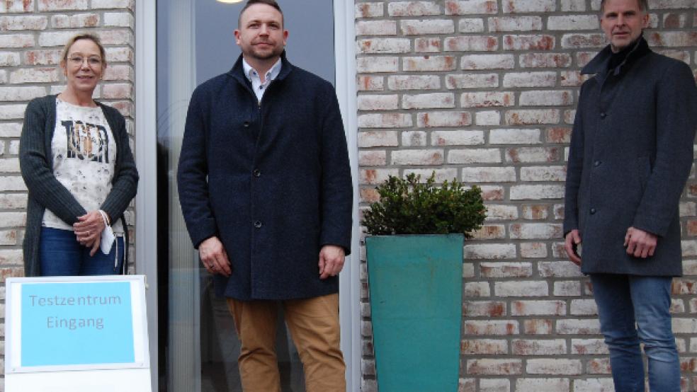 Hinter dieser Tür des Firmengebäudes sind die technischen Anlagen zu finden, die Schnelltests finden auf Parkplatz nach dem »Drive In«-Prinzip statt. Im Bild von links: Jutta und Matthias Sap mit dem Ersten Stadtrat Hermann Welp.  © Foto: Hoegen