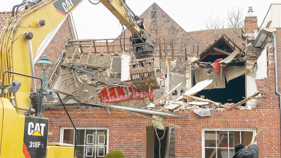 Präzisionsarbeit: Das Haus der Versicherungsagentur Oorlog in Bunde wird abgerissen. Im Hintergrund: die Kirche.  © Foto: Hanken