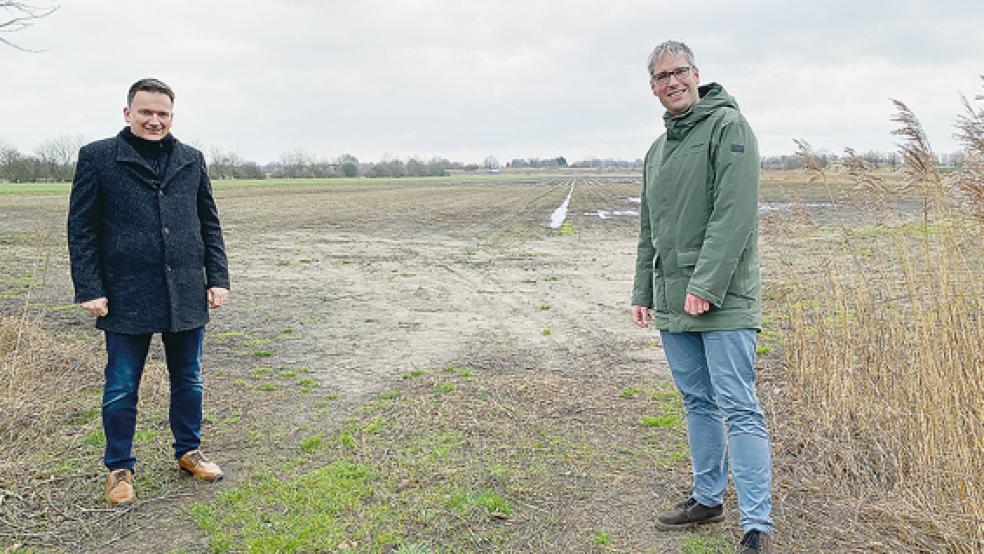 Herz für Hunde: Die Bürgermeister Uwe Sap (Bunde, links) und Heiko Abbas (Weener) vor der geplanten Freilauf­fläche für Hunde an der Boenster Straße.  © Foto: Hanken