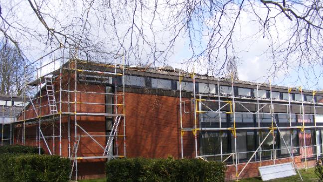 Handwerker steigen DGH aufs Dach