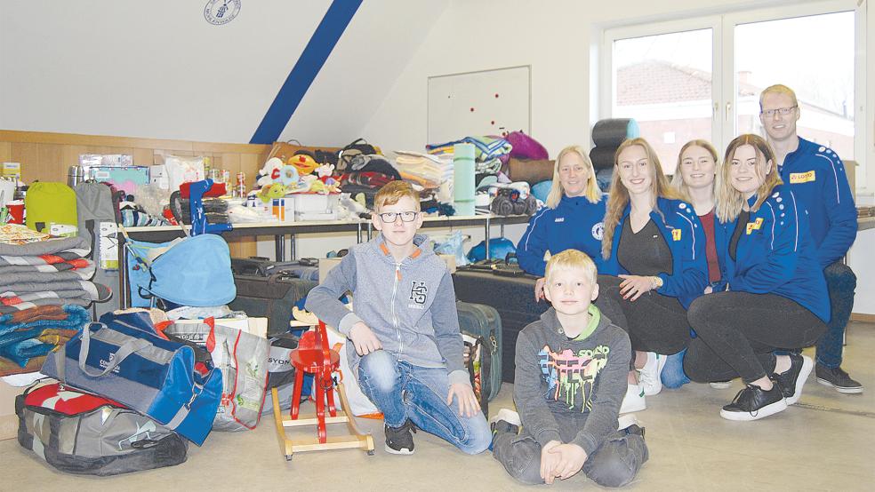 Freuen sich über das große Spendenaufkommen: Vorne Damian und Julian Auen, hinten von links Doris Auen, Deike Engberts, Loressa Trey, Rieke Modderman und Helmut Auen. Die Spenden werden bis zum Transport nach Moormerland in einem Raum im ersten Stock des Vereinsheims der Sportfreunde gelagert.  © Foto: Hoegen
