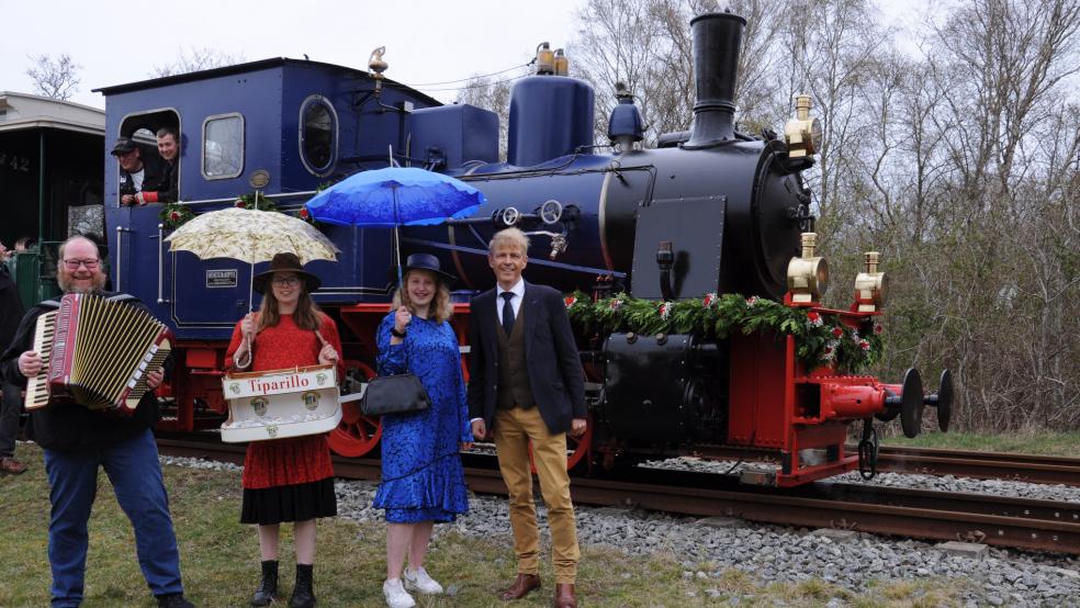 Die Dampflok „Borkum“ bei der Sonderfahrt mit Akkordeonspieler Albertus Akkermann, Lilly Lorch und Eske Bakker sowie den Geschäftsführer der Borkumer Kleinbahn Dr. Bernhard Brons; auf der Lok Michael Watermann und Markus Grass. © AG Ems